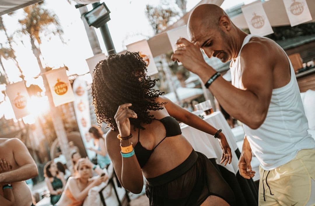 Pareja bailando en un beach club al atardecer en Gran Canaria, fotografía de eventos por Fer Herrera