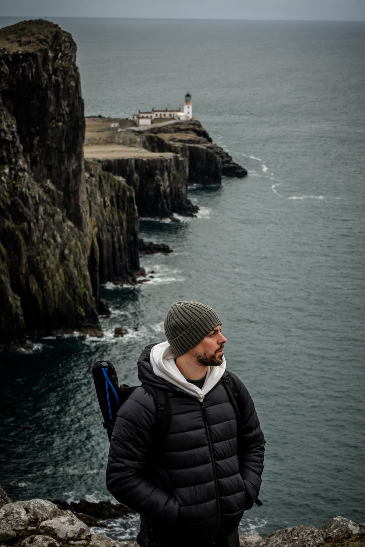 Retrato de Fer Herrera frente a acantilados y un faro en la costa, fotógrafo y videógrafo en Las Palmas de Gran Canaria